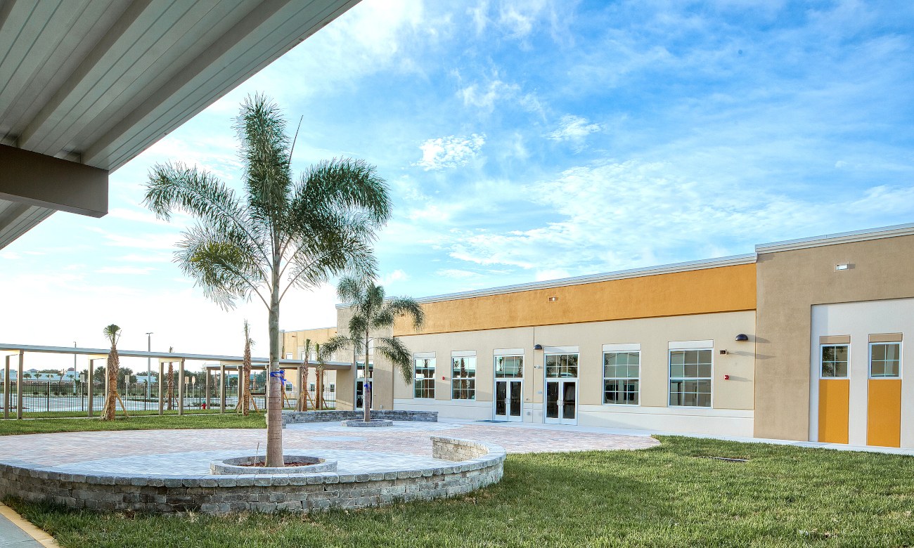 School courtyard with palm trees and seating