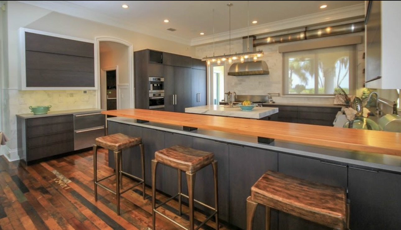 Dark kitchen cabinetry with wood breakfast bar