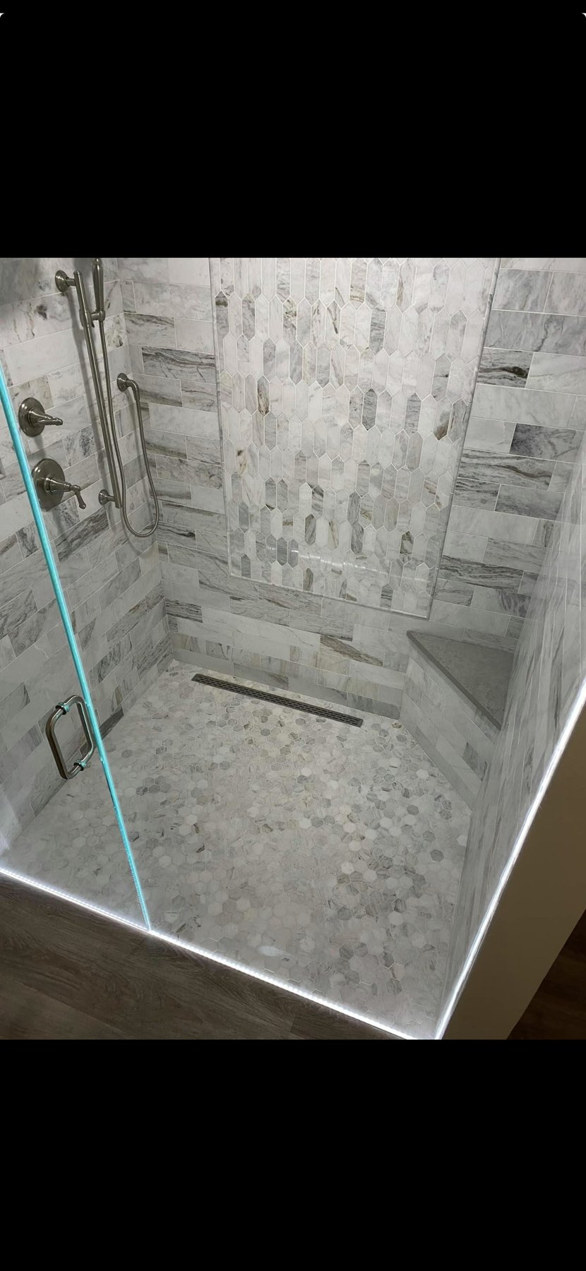 Walk-in shower with patterned stone tile
