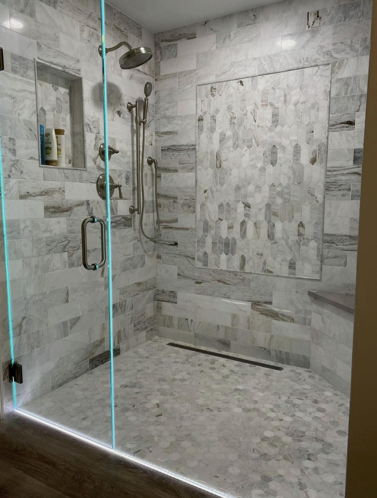 Stone-tiled shower with glass enclosure