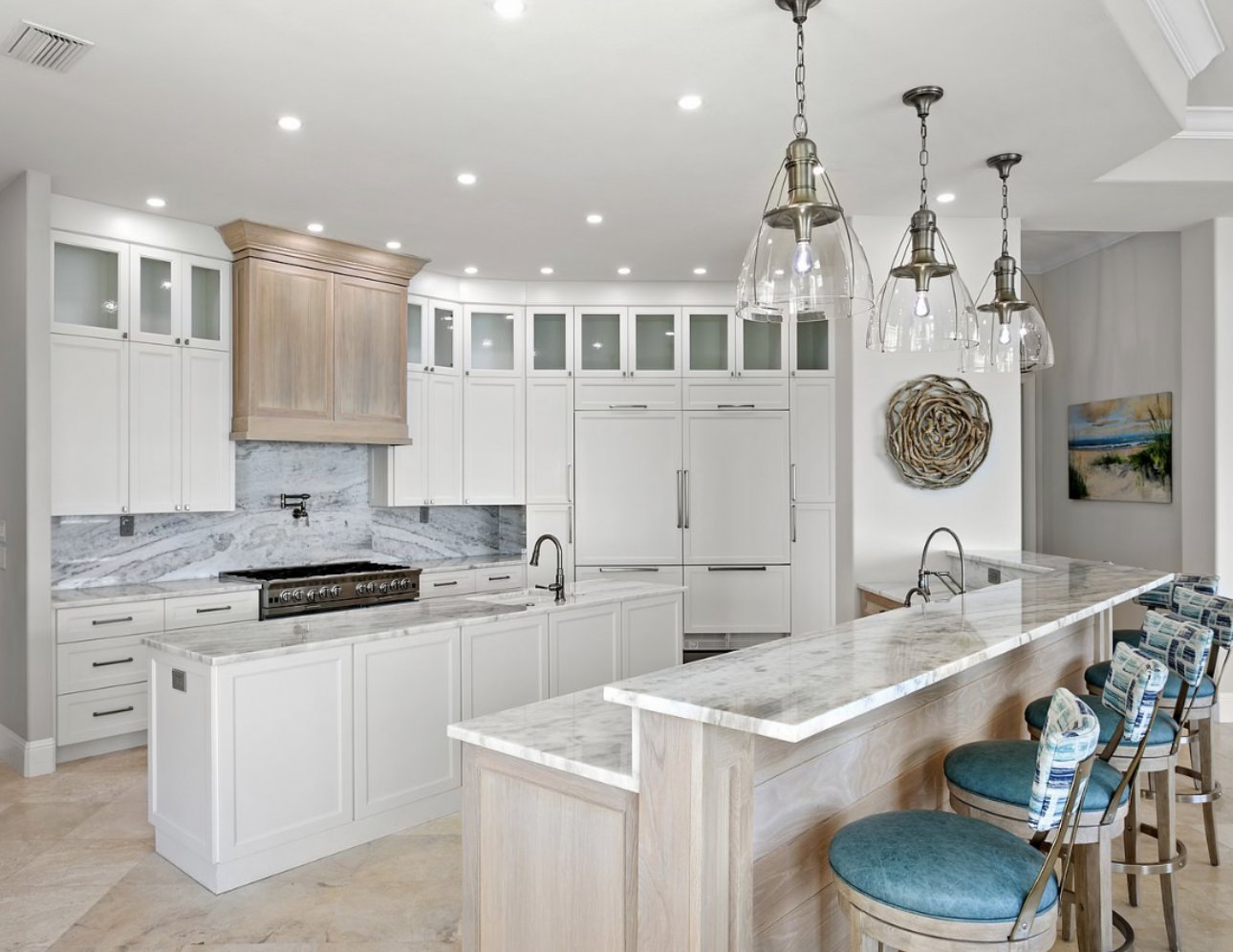 White kitchen with large island and blue bar stools