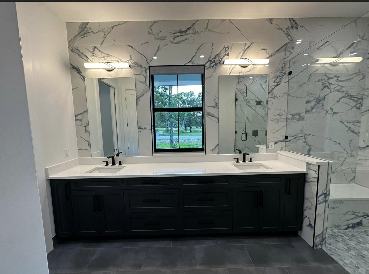 Bathroom vanity with dark cabinetry and stone walls