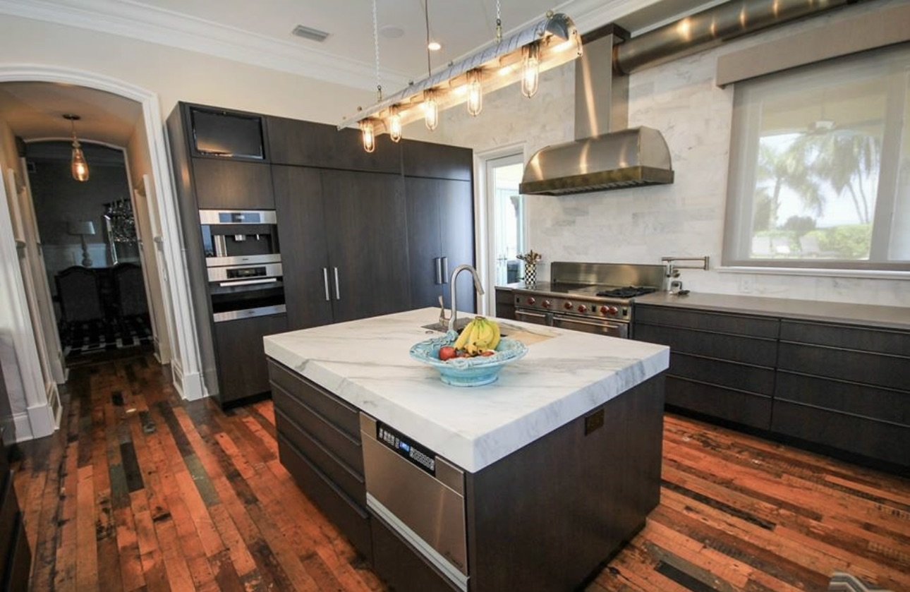 Kitchen with dark cabinetry and stainless range hood