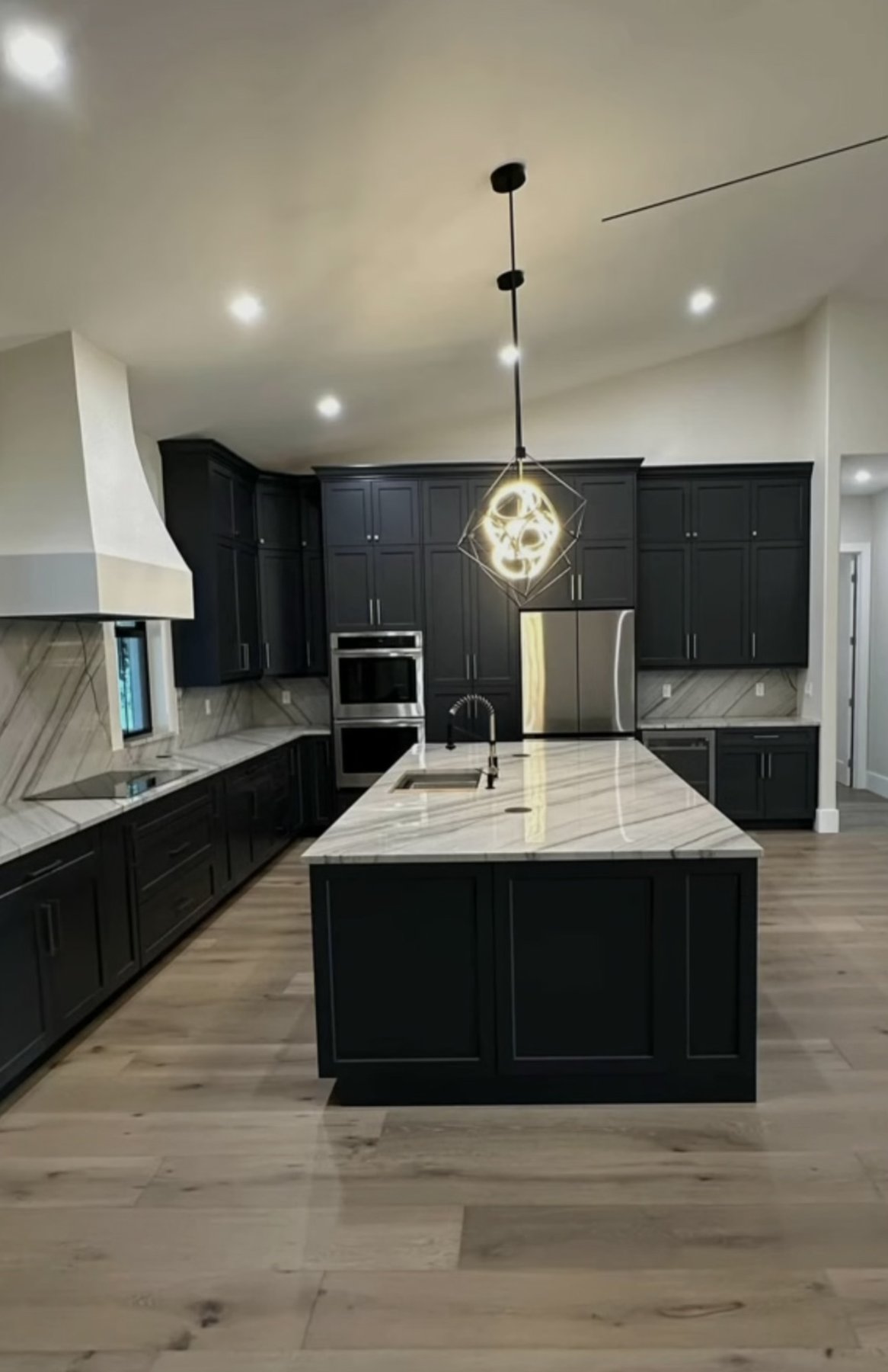 Kitchen with dark island and pendant lights