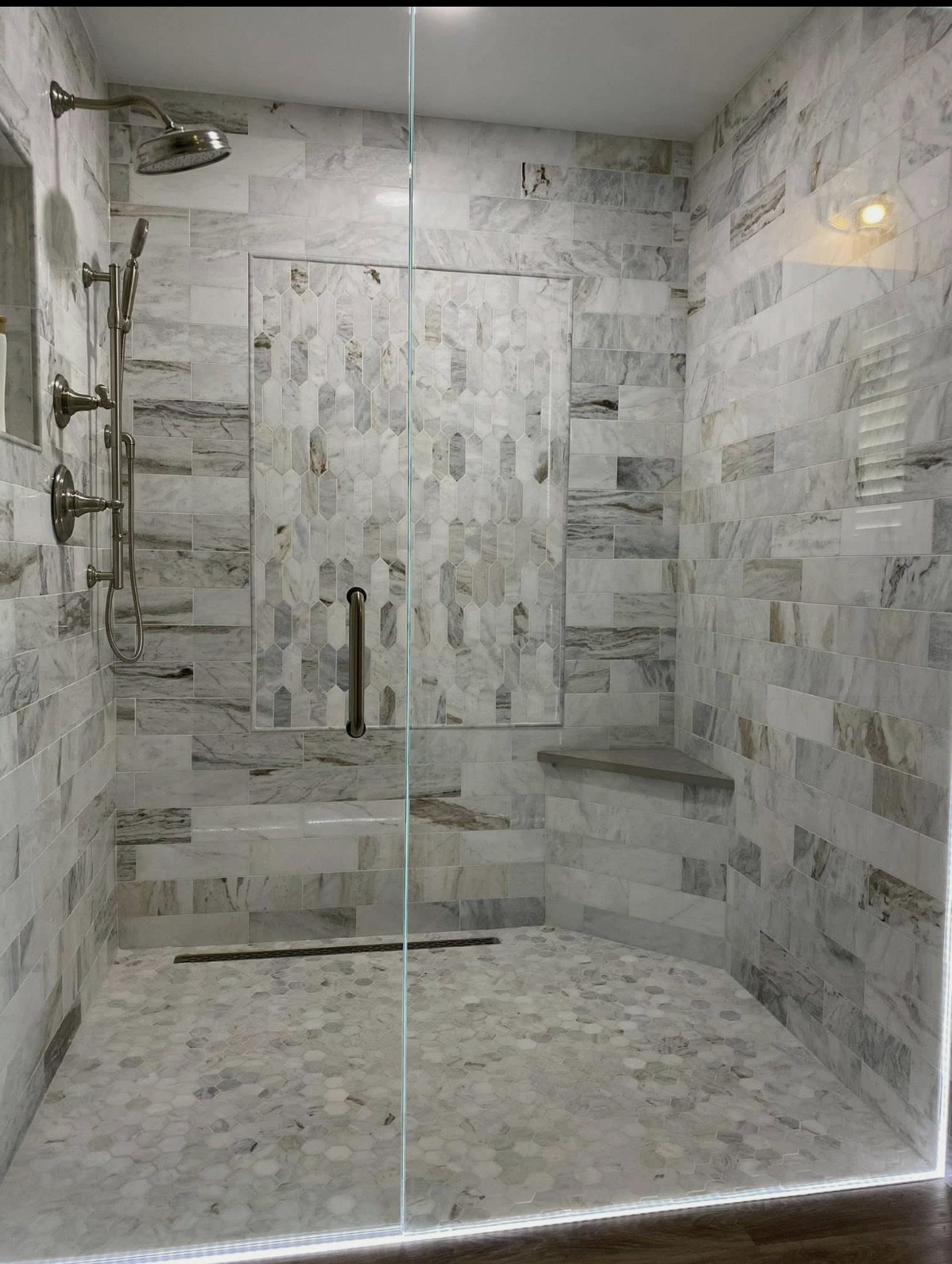 Walk-in shower with stone walls and glass doors